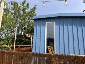 Sitzgelegenheit auf Holzterrasse vor Tiny Haus